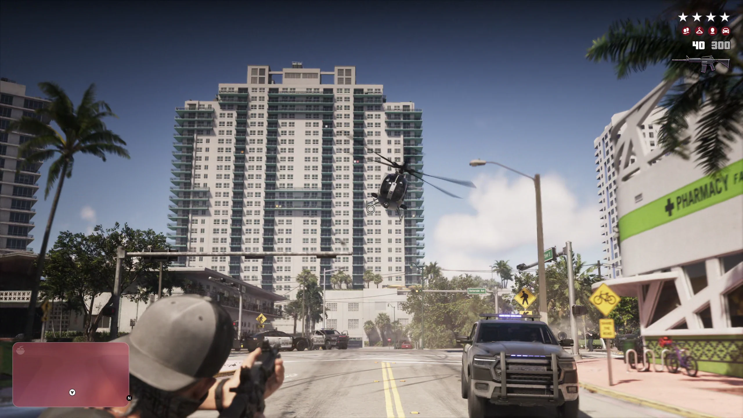 A four-star police chase on a Vice City street: a helicopter overhead, patrol cars ahead and alongside, the wanted stars and heat indicators in the top corner, and a red search area filling the minimap